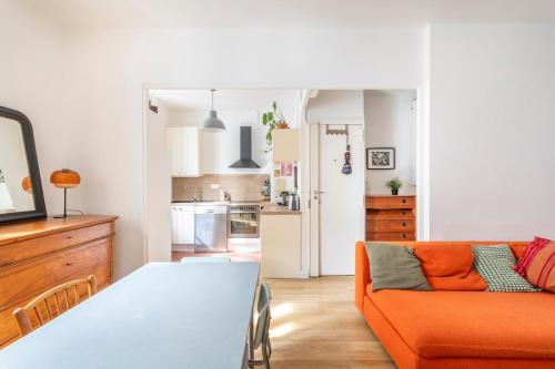 un salon avec un canapé orange et une cuisine dans l'établissement Appartement coloré proche de la mer, à Marseille