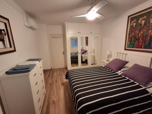 a bedroom with a black and white striped bed at Apartamento frente a la playa Piso 2 in Estepona