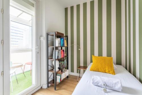 - une chambre avec un lit doté d'un oreiller jaune et d'une étagère à livres dans l'établissement Appartement coloré proche de la mer, à Marseille