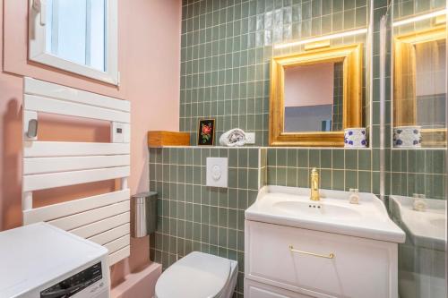 une salle de bain avec un lavabo, des toilettes et un miroir dans l'établissement Appartement coloré proche de la mer, à Marseille