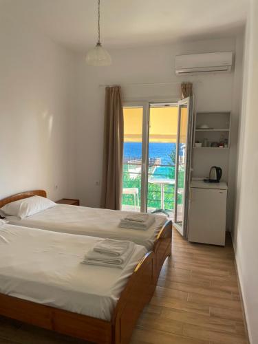 a bedroom with a bed and a view of the ocean at NAFSIKA Apartments in Agios Georgios Pagon