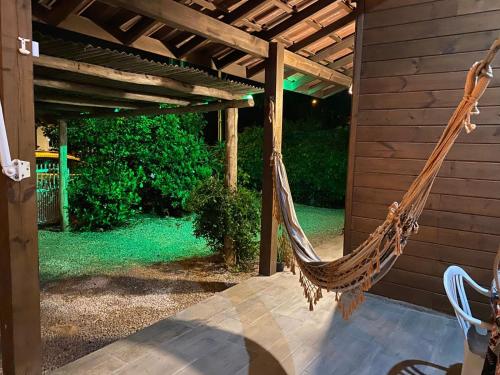a hammock on a porch of a house at Cabanas dos Sonhos 2- Barra de Ibiraquera in Imbituba