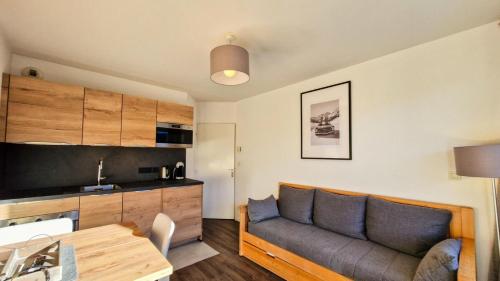 un salon avec un canapé et une table dans l'établissement Résidence Les Pleiades - Appartement lumineux avec parking couvert · Centre station · Balcon MAE-7393, à Flaine