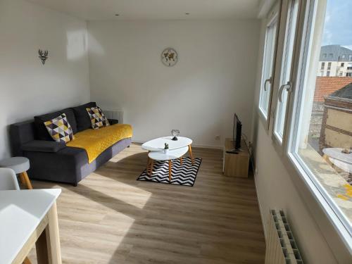 un salon avec un canapé et une table dans l'établissement Le cocon Dieppois - Appt spacieux avec parking privé, à Dieppe
