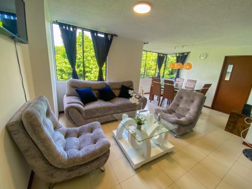un soggiorno con due divani e un tavolo di Apartamento Sur De Cali Santa Anita Excelente Ubicación a Cali