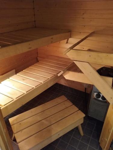 a wooden bunk bed with two benches in a room at Kaksio Kivitipun lähellä in Lappajärvi