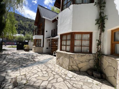 a house with a stone walkway in front of it at Holiday Home Las Retamas in San Martín de los Andes