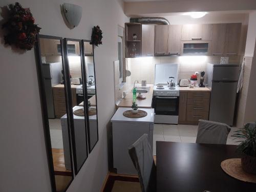 a kitchen with wooden cabinets and a table with a dining room at Sorin Apartments Gevgelija in Gevgelija