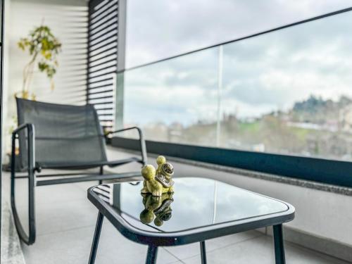 a table and two chairs on a balcony with a window at Bragança Holiday Home new apartment with 2 bedrooms private parking in Bragança