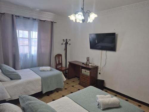 a bedroom with two beds and a flat screen tv at Los Molinos in Valles de Ortega