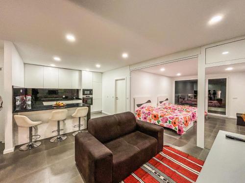 a bedroom with a couch and a bed and a kitchen at Bragança Holiday Home new apartment with 2 bedrooms private parking in Bragança