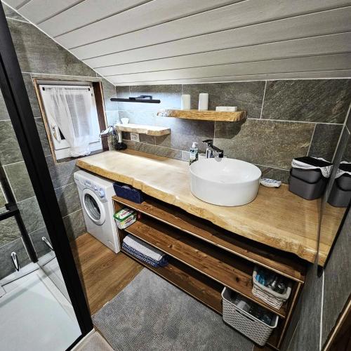 une salle de bain avec un lavabo et une machine à laver dans l'établissement location05220 duplex 6 lits, au Monêtier-les-Bains
