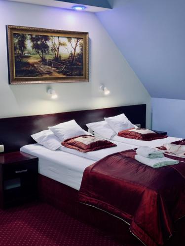 a hotel room with two beds and a picture on the wall at EdMar in Malbork