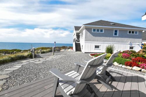 un patio con 2 sillas, una casa y el océano en Ocean Views Steps to Private Beach A C, en Truro