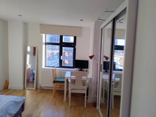 a room with a table and a desk with a computer at Fantastic location private Deluxe Ensuite bathroom Shoreditch Hoxton spitalfields Liverpool st London Bridge city 2 Rooms luxury Doubles for 5 guests in London