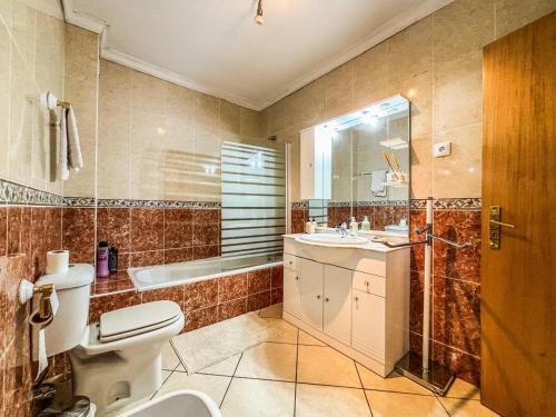 Un baño con inodoro, lavabo y ducha. en Family holiday home new beds, en Bragança