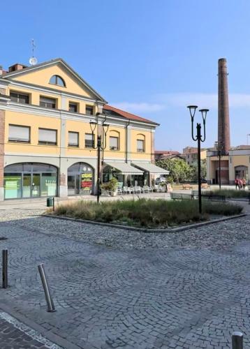 a large yellow building with a street in front of it at Casa Vizz in Melegnano