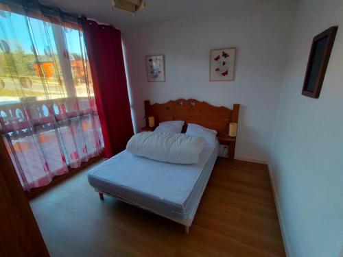 une chambre avec un lit et une grande fenêtre dans l'établissement La Pradella Bolquere T3 PYRENEES 2000, à Bolquère-Pyrénées 2000