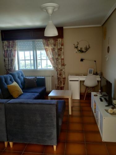 ein Wohnzimmer mit einem blauen Sofa und einem Tisch in der Unterkunft Doniños Paraíso in Ferrol