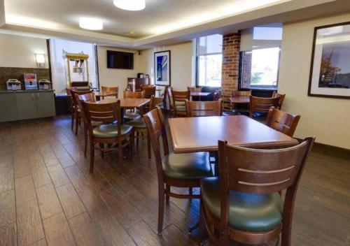 a dining room with wooden tables and chairs at Wingate by Wyndham St Louis-Fenton Route 66 in Fenton