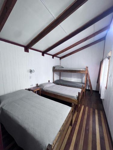 two bunk beds in a room with wooden floors at Cabañas Gabella in Lago Ranco