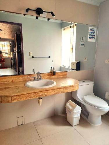 a bathroom with a sink and a toilet and a mirror at NAIA Miraflores Lima- Formerly Selina Miraflores Lima in Lima
