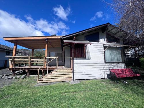 a small white house with a porch and a deck at Cabañas Gabella in Lago Ranco