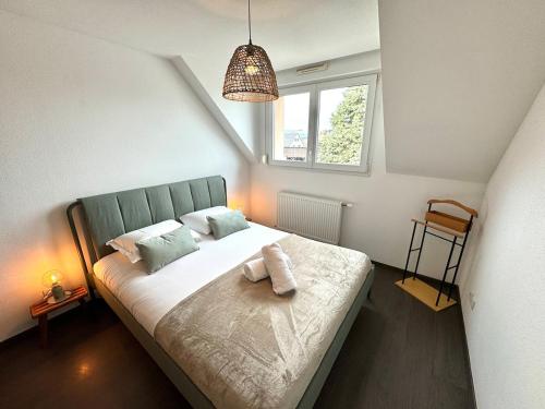 une chambre avec un lit avec des oreillers et une fenêtre dans l'établissement Le belle vue à Horbourg-Whir, à Horbourg-Wihr