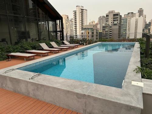uma grande piscina com espreguiçadeiras num edifício em Studio 500m from Allianz Parque em São Paulo