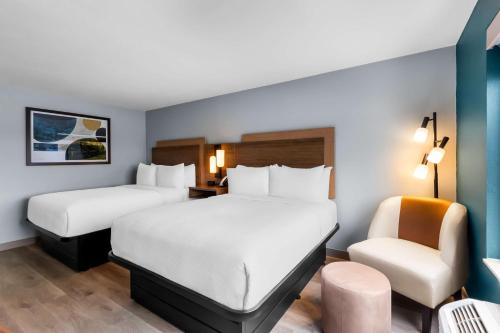 a hotel room with two beds and a chair at Best Western Plus Fenton in Fenton