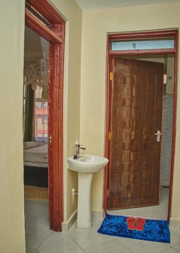 a bathroom with a sink and a door with a mirror at Urban Oasis in Kakamega