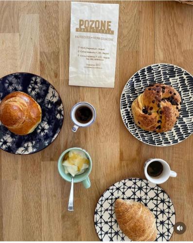 een tafel met drie borden eten en koffie bij B&B Pantarei Napoli in Napels