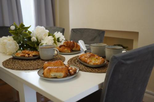 a table with plates of pastries and cups of coffee at Excellency Stays , Contractors ,families , Comfort Home , Free Parking , in Kent