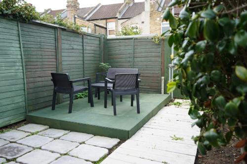 two chairs and a table in a garden at Excellency Stays , Contractors ,families , Comfort Home , Free Parking , in Kent