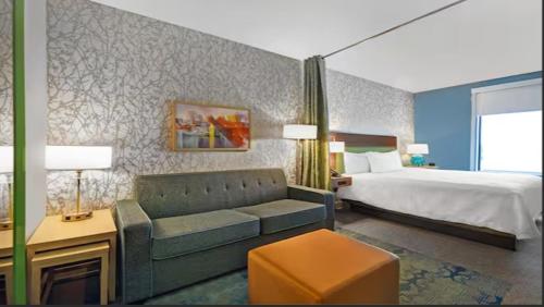 a hotel room with a bed and a couch and a bed at Home2 Suites By Hilton Utica, Ny in Utica