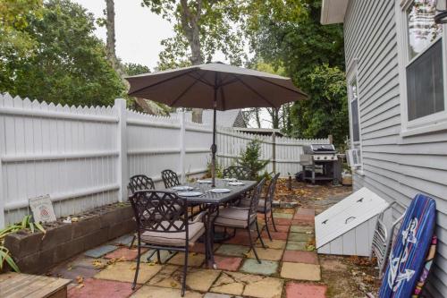 a table and chairs with an umbrella on a patio at On the bay in Wellfleet - walk to water! in Wellfleet