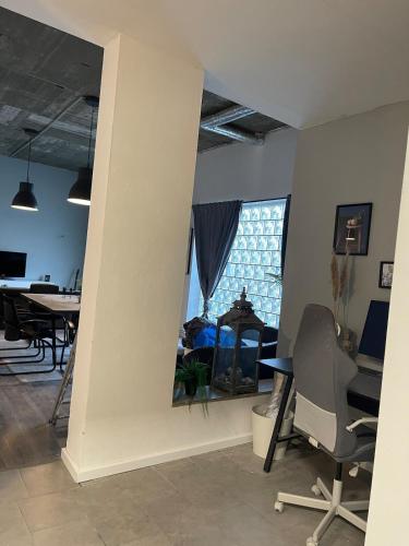 a living room with a large window and a table and chairs at Unique loft for 8 in Eggenstein-Leopoldshafen