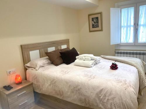 a bedroom with a bed with two towels on it at Pension A Casiña D,avoa Oseira in Osera