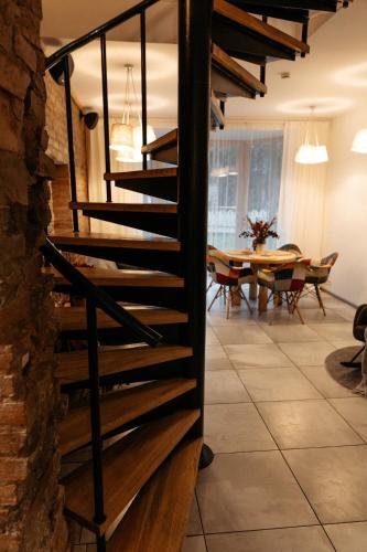 a wooden staircase in a room with a table at Upene Home in Iecava