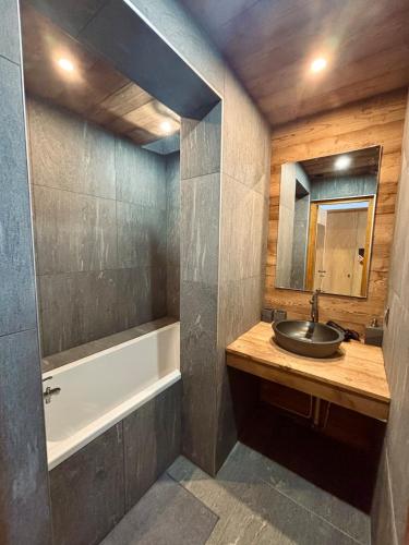 une salle de bain avec un lavabo et une baignoire dans l'établissement Charmant appartement aux portes de Megeve, à Demi-Quartier