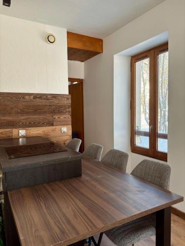 une salle à manger avec une table et des chaises en bois dans l'établissement Charmant appartement aux portes de Megeve, à Demi-Quartier