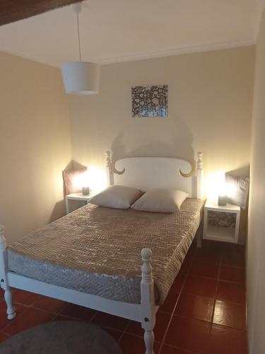 a bedroom with a white bed with two pillows at Village Sun House - Porto Moniz in Porto Moniz