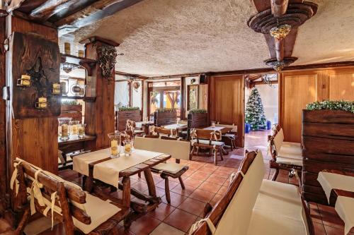 restauracja ze stołami i krzesłami oraz choinką świąteczną w obiekcie Hotel - Karczma Klimtówka w mieście Wolbrom