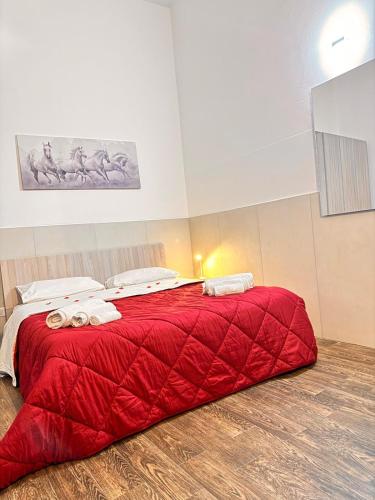 a red bed with two towels on top of it at marsala centro storico in Marsala