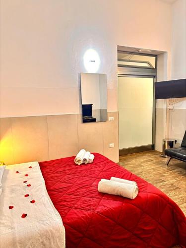 a bedroom with a red bed with two towels on it at marsala centro storico in Marsala
