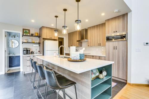 a kitchen with a large island with bar stools at Furnished Deck, Mountain View Castle Rock Home! in Castle Rock