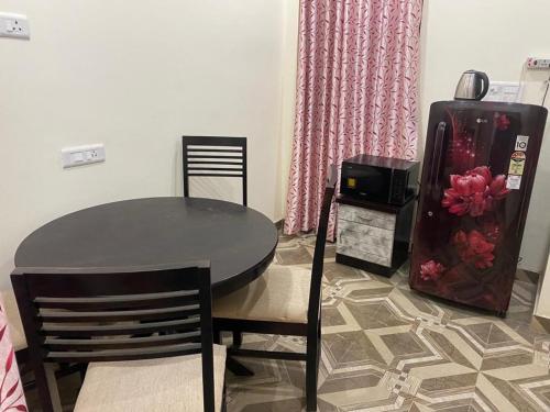 Un comedor con una mesa y un refrigerador. en Shakuntalam, en Prayagraj