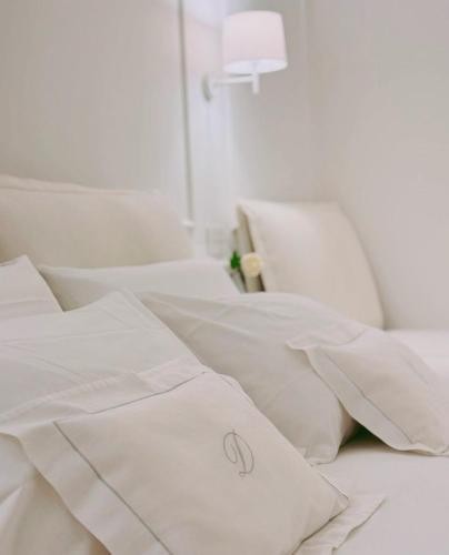 a white bed with white sheets and pillows at DIMORA CARDUCCI in Bari