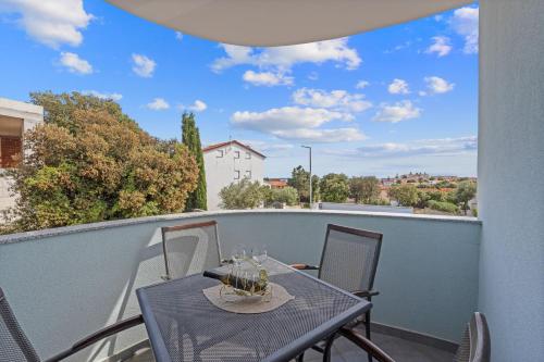 Una mesa y sillas en un balcón con vista. en Mery's Sunny Pool Apartment - Happy Rentals, en Vodnjan