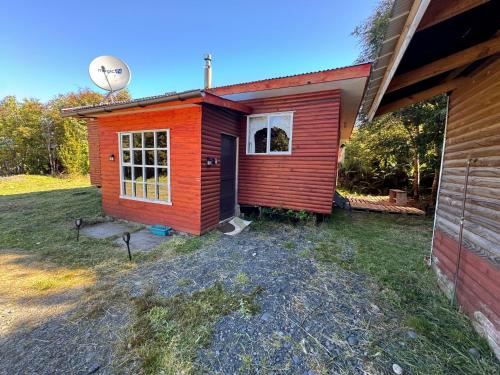 a small red house on the side of a house at "Cabaña A y M" in Chaitén
